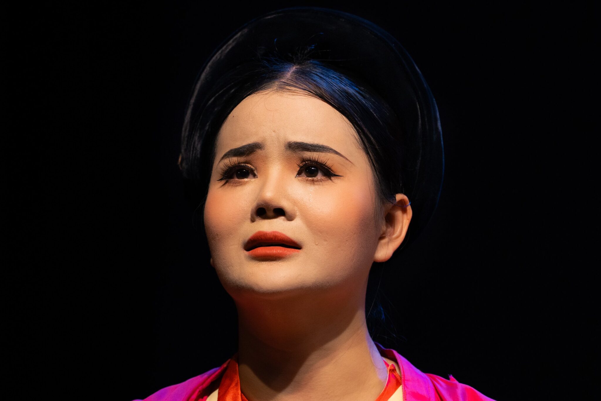 Close-up of an actress in tears, looking upward