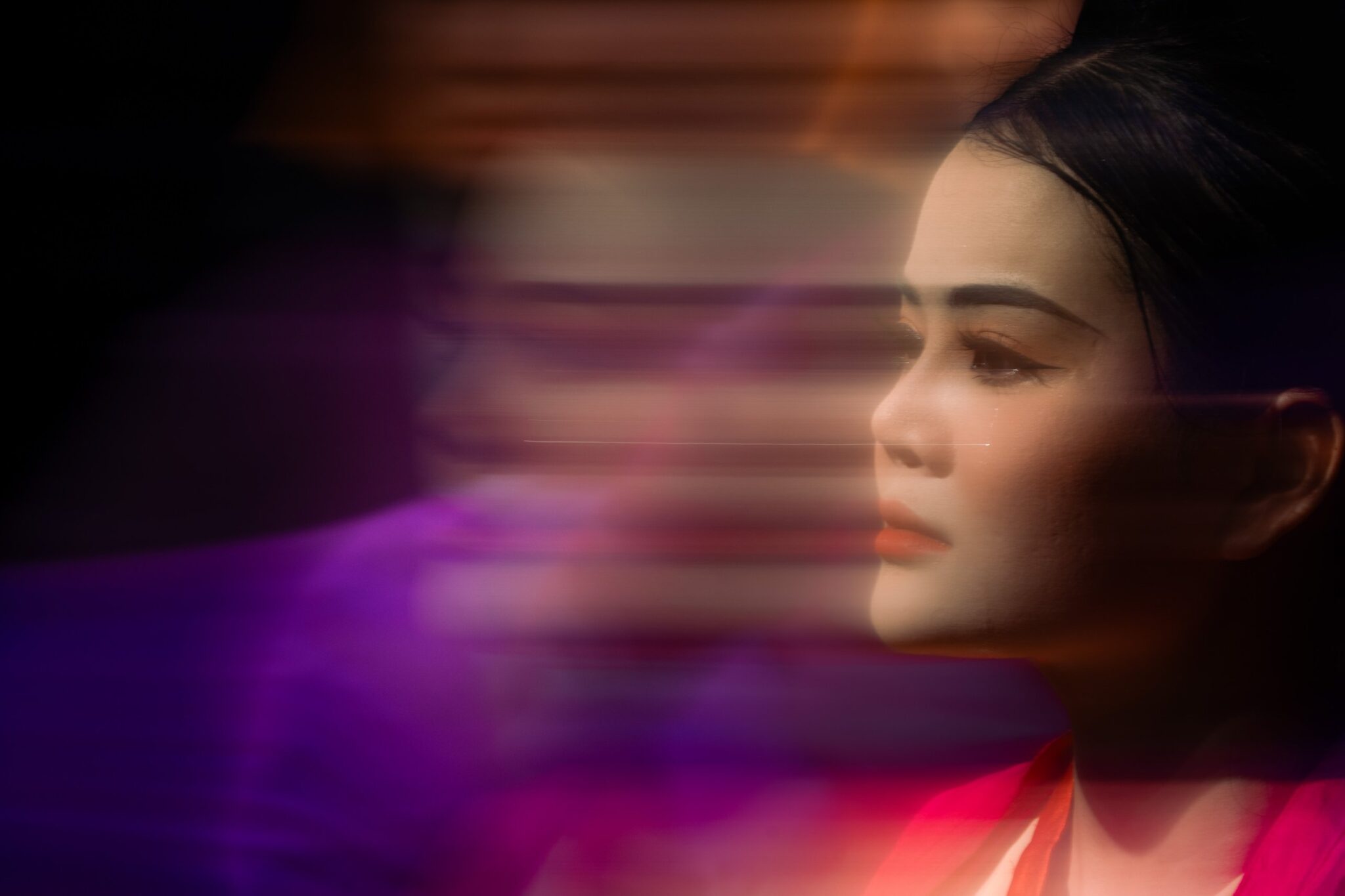 Tearful actress in profile beside a sweep of purple motion blur