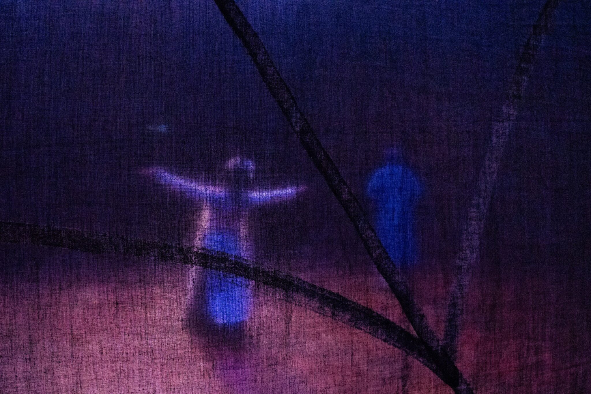 Figures seen through a painted translucent stage screen in purple light