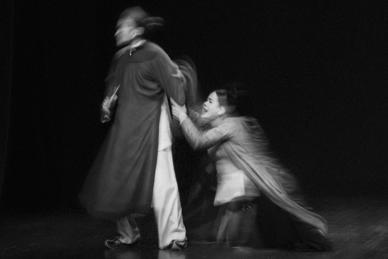 Suý Vân: actress kneeling and clutching the robe of a man as he turns away, in black and white